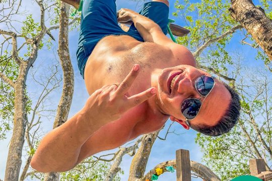 Cliente no balanço, de cabeça para baixo e sorrindo em Jericoacoara